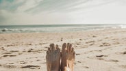 womans feet on beach