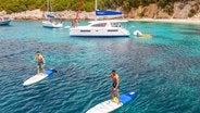 Catamaran Anchoring and People Stand Up Paddling Corfu Island